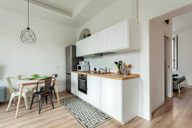 Idee per una cucina moderna di medie dimensioni con top in legno e parquet chiaro