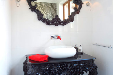 This is an example of a large eclectic powder room in Other with a wall-mount toilet, white tile, porcelain tile, white walls, marble floors, a vessel sink and black floor.