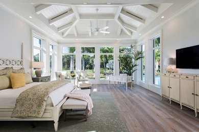 Bedroom - large tropical master light wood floor and beige floor bedroom idea in Denver with white walls