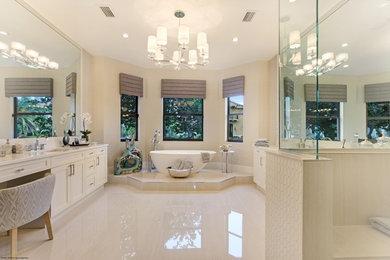 This is an example of a contemporary master bathroom in Miami with white cabinets, a freestanding tub and a corner shower.