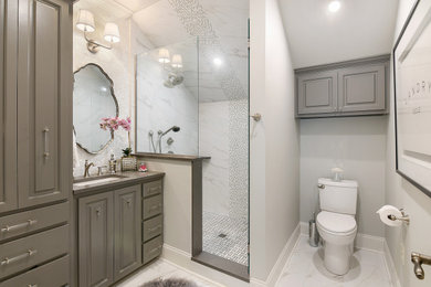Inspiration for a mid-sized transitional 3/4 white tile and marble tile ceramic tile, white floor, single-sink and wallpaper bathroom remodel in Other with gray cabinets, a one-piece toilet, white walls, an undermount sink, quartzite countertops, a hinged shower door, gray countertops, a built-in vanity and raised-panel cabinets