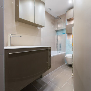 Immagine di una piccola stanza da bagno padronale minimalista con lavabo da incasso, ante lisce, ante marroni, top in superficie solida, vasca sottopiano, vasca/doccia, WC sospeso, piastrelle beige, piastrelle in terracotta, pareti marroni e pavimento in terracotta