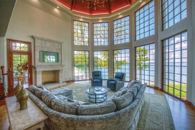Living room - large transitional open concept medium tone wood floor and brown floor living room idea in Other with beige walls, a standard fireplace, a stone fireplace and no tv