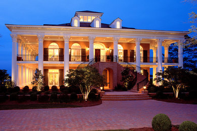 Example of a huge classic white two-story mixed siding flat roof design in Other