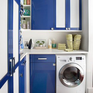 Inspiration for a small modern l-shaped utility room in New York with a built-in sink, flat-panel cabinets, blue cabinets, laminate countertops, white walls, medium hardwood flooring and an integrated washer and dryer.
