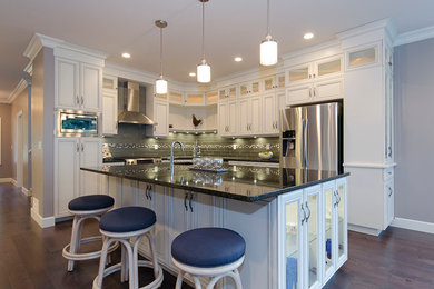 Eat-in kitchen - mid-sized transitional l-shaped eat-in kitchen idea in Vancouver with a drop-in sink, beaded inset cabinets, white cabinets, green backsplash, stainless steel appliances and an island