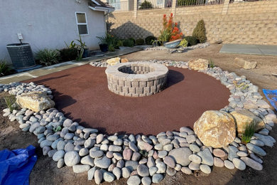 Inspiration for a mid-sized contemporary drought-tolerant and full sun backyard decomposed granite and stone fence landscaping in San Diego with a fire pit for summer.