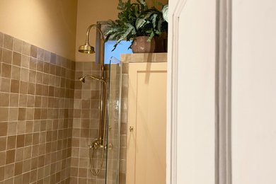 Small contemporary family bathroom in London with shaker cabinets, beige cabinets, a built-in bath, a shower/bath combination, a one-piece toilet, beige tiles, cement tiles, beige walls, ceramic flooring, a built-in sink, marble worktops, beige floors, a hinged door, yellow worktops, a single sink and a built in vanity unit.