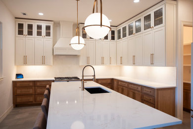 Eat-in kitchen - mid-sized modern l-shaped ceramic tile, gray floor and tray ceiling eat-in kitchen idea in Austin with an undermount sink, shaker cabinets, light wood cabinets, quartz countertops, white backsplash, quartz backsplash, white appliances, an island and white countertops