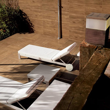 Modern backyard patio with pool using our wood grain porcelain wood deck tiles