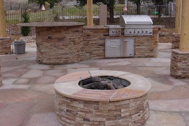 Mid-sized southwest backyard stone patio kitchen photo in Albuquerque with a pergola