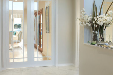 Inspiration for a contemporary entryway in Gold Coast - Tweed with beige walls and ceramic floors.