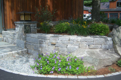 Inspiration for a mid-sized partial sun front yard stone landscaping in Boston.