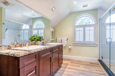 Alcove shower - mid-sized craftsman master double-sink, ceramic tile and beige floor alcove shower idea in Boston with shaker cabinets, red cabinets, granite countertops, beige countertops, a built-in vanity, a two-piece toilet, green walls, a drop-in sink and a hinged shower door