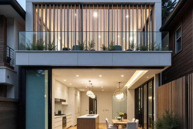 Ejemplo de fachada de casa blanca y blanca minimalista de tamaño medio de dos plantas con revestimientos combinados, tejado plano y tejado de varios materiales