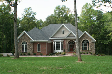 Mid-sized traditional multicolored two-story stone house exterior idea in DC Metro with a hip roof and a shingle roof