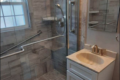 Example of a small minimalist master beige tile and ceramic tile laminate floor, brown floor and single-sink bathroom design in New York with shaker cabinets, white cabinets, a two-piece toilet, beige walls, an integrated sink, beige countertops and a freestanding vanity