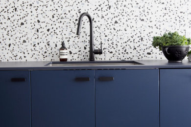 Trendy kitchen photo in Vancouver with flat-panel cabinets, blue cabinets and solid surface countertops