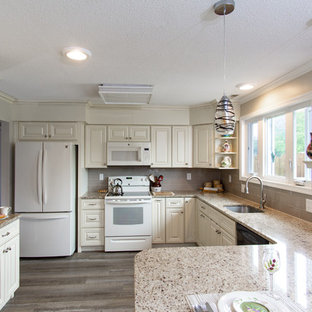 Photo of a mid-sized traditional u-shaped kitchen pantry in Philadelphia with an undermount sink, raised-panel cabinets, white cabinets, granite benchtops, grey splashback, subway tile splashback, white appliances, laminate floors, a peninsula, multi-coloured floor and multi-coloured benchtop.
