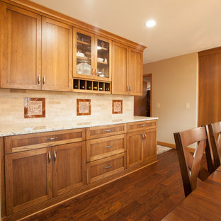 Aménagement d'une arrière-cuisine classique en U avec un placard à porte shaker, des portes de placard marrons, un électroménager en acier inoxydable et un îlot central.