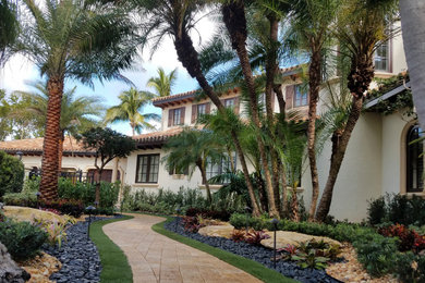 Photo of an expansive traditional garden in Miami with natural stone pavers.