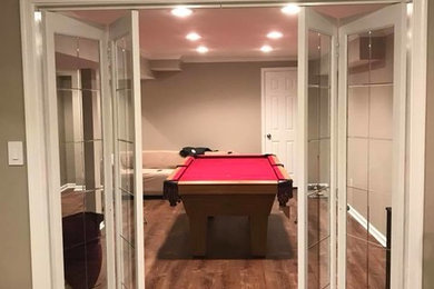 Basement - large traditional underground medium tone wood floor and brown floor basement idea in Philadelphia with brown walls