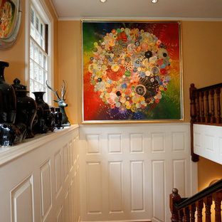 Exempel på en stor eklektisk foajé, med gula väggar, mellanmörkt trägolv, en enkeldörr och en röd dörr