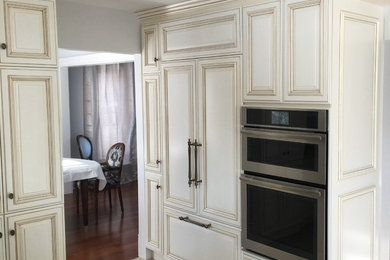 Eat-in kitchen - small contemporary u-shaped porcelain tile and gray floor eat-in kitchen idea in Montreal with an undermount sink, raised-panel cabinets, beige cabinets, solid surface countertops, beige backsplash, ceramic backsplash, stainless steel appliances and multicolored countertops