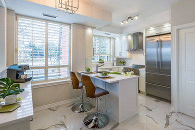 Example of a mid-sized trendy u-shaped porcelain tile enclosed kitchen design in Toronto with a single-bowl sink, shaker cabinets, white cabinets, quartz countertops, white backsplash, porcelain backsplash, stainless steel appliances and an island