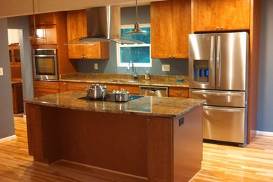 Open concept kitchen - mid-sized traditional galley light wood floor open concept kitchen idea in Baltimore with an undermount sink, medium tone wood cabinets, granite countertops, stainless steel appliances, an island and shaker cabinets