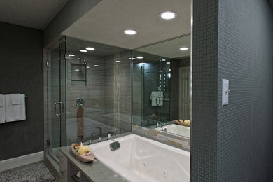 Large trendy master gray tile and porcelain tile porcelain tile bathroom photo in Austin with a drop-in sink, flat-panel cabinets, gray cabinets, solid surface countertops, a two-piece toilet and gray walls