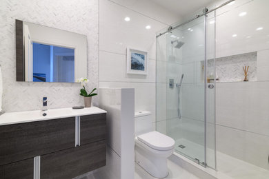 Minimalist white tile and marble tile porcelain tile, white floor and single-sink bathroom photo in Miami with flat-panel cabinets, dark wood cabinets, a one-piece toilet, white walls, a drop-in sink, white countertops and a floating vanity