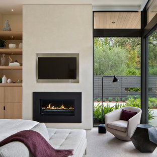 Bild på ett funkis huvudsovrum, med beige väggar, heltäckningsmatta och en bred öppen spis