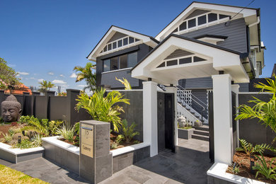 Large modern two-storey black house exterior in Brisbane with wood siding.