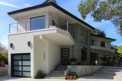 Inspiration for a large modern multicolored two-story stucco house exterior remodel in San Francisco with a metal roof