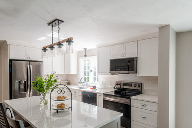 Large transitional l-shaped ceramic tile and beige floor eat-in kitchen photo in Boston with an undermount sink, shaker cabinets, white cabinets, quartz countertops, white backsplash, subway tile backsplash, stainless steel appliances, an island and white countertops