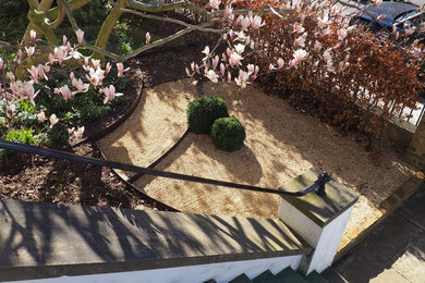 Photo of a large contemporary front full sun garden for spring in London with gravel.