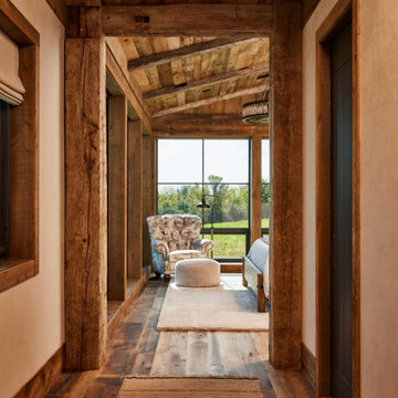 Hand Hewn Timbers and Weathered Antique Paneling in Rustic Farmhouse Hallway