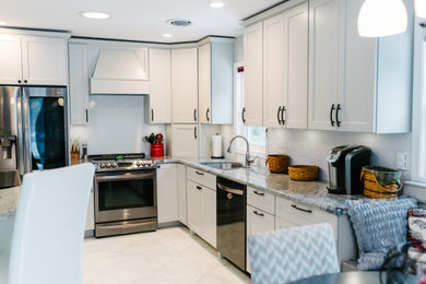 Inspiration for a large timeless l-shaped white floor eat-in kitchen remodel in Philadelphia with a double-bowl sink, shaker cabinets, white cabinets, granite countertops, white backsplash, subway tile backsplash, stainless steel appliances, an island and gray countertops