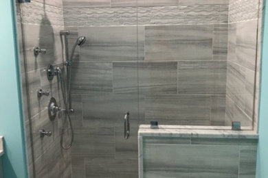 Photo of a mid-sized traditional bathroom in Boston with shaker cabinets, grey cabinets, an alcove shower, a two-piece toilet, gray tile, ceramic tile, green walls, marble floors, an undermount sink, marble benchtops, grey floor and a hinged shower door.