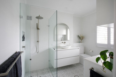 Photo of a mid-sized transitional bathroom in Brisbane with flat-panel cabinets, white cabinets, a corner shower, ceramic tile, mosaic tile floors, a vessel sink, engineered quartz benchtops, grey floor, a hinged shower door, white benchtops, a laundry, a single vanity and a floating vanity.