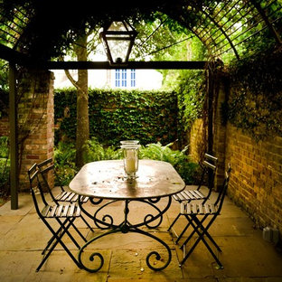 This is an example of a traditional patio in New Orleans with a gazebo/cabana.