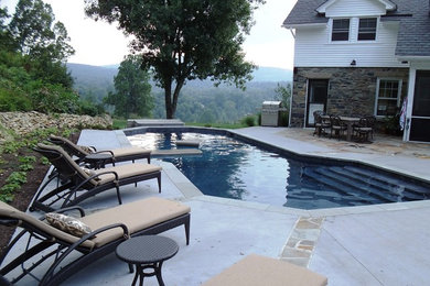 This is an example of a large traditional backyard custom-shaped lap pool in DC Metro with concrete slab.