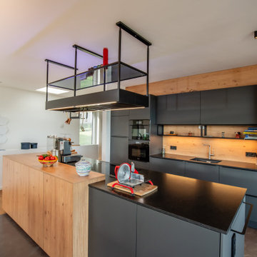 Moderne Küche mit dunklen Fronten und Holz
