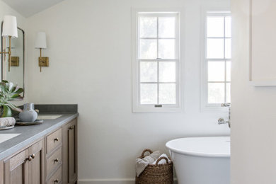 Bathroom - mid-sized transitional master white tile and porcelain tile cement tile floor, gray floor, double-sink and vaulted ceiling bathroom idea in San Francisco with recessed-panel cabinets, medium tone wood cabinets, a bidet, white walls, a drop-in sink, a hinged shower door, gray countertops and a built-in vanity