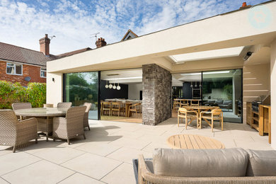 Large contemporary back patio in Berkshire with an outdoor kitchen and a roof extension.