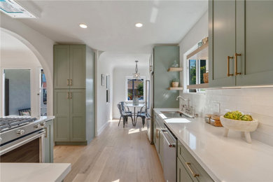 Inspiration for a contemporary eat-in kitchen remodel in Los Angeles with a double-bowl sink, shaker cabinets, white backsplash, stainless steel appliances and white countertops