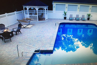 Mid-sized elegant backyard brick and l-shaped lap pool photo in Providence