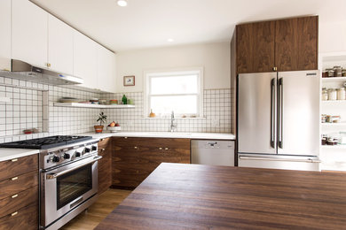 Mid-sized modern galley eat-in kitchen in Portland with an undermount sink, flat-panel cabinets, medium wood cabinets, quartz benchtops, white splashback, ceramic splashback, stainless steel appliances, light hardwood floors, with island, brown floor and white benchtop.