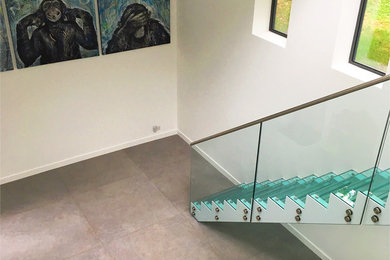 Design ideas for a medium sized modern glass straight glass railing staircase in Berkshire with open risers.